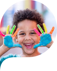 boy with paint on hand smiling