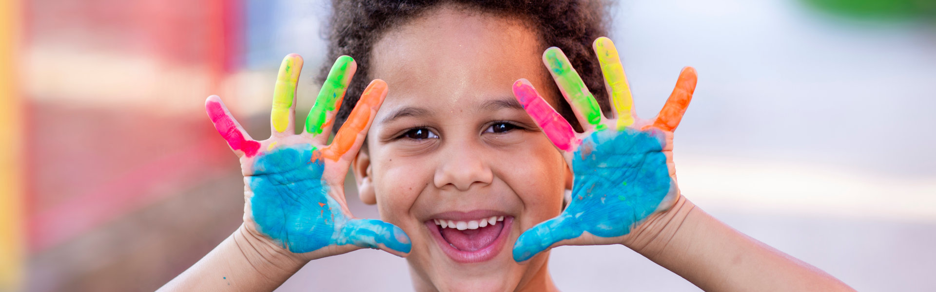 boy with paint on hand smiling